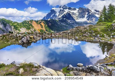 ARTIST POINT, WASHINGTON  - AUGUST 19, 2017 Hikers Mount Shuksan Pool Reflection Summer Artist Point Mount Baker Highway Pacific Northwest Washington State Snow Mountain Grass Trees