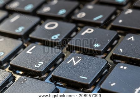 Close-up electronic of laptop keyboard with focus on button, keyboard for writing in Spanish, Castilian