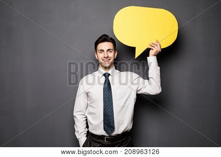 Businessman Holding Speech Bubble On Gray Background