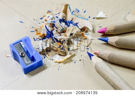 Crayons And Pencil Sharpener On A Wooden Office Table. Crayons With Sharpening Crayons And Pencils O