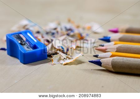 Crayons And Pencil Sharpener On A Wooden Office Table. Crayons With Sharpening Crayons And Pencils O