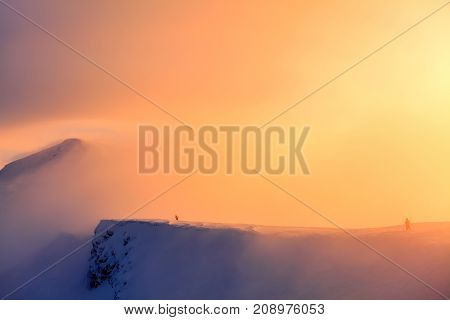 Unbelievable day on the snowy hill from the life of free- rider. Mountains in fog. Morning lights. Fantastic winter scenery.