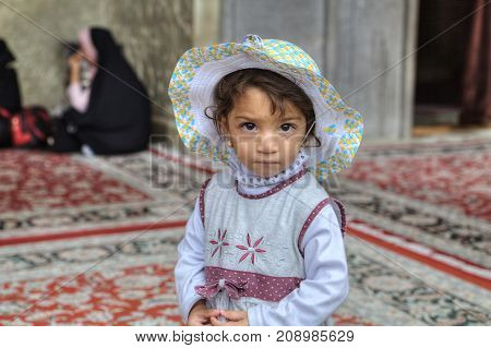 Fars Province Shiraz Iran - 19 april 2017: Shah Cheragh Shrine Close-up portrait of an unknown Iranian girl about four years old standing in the courtyard of the mosque.