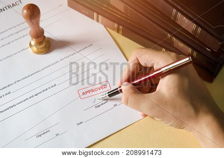 Notary signing a contract with fountain pen. Red Approved stamp. business man law attorney lawyer notary public