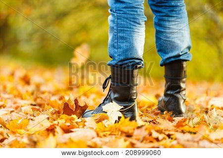 Nature outdoor foliage relax concept. Man in black boots. Male in leather footwear jeans trousers standing outside.