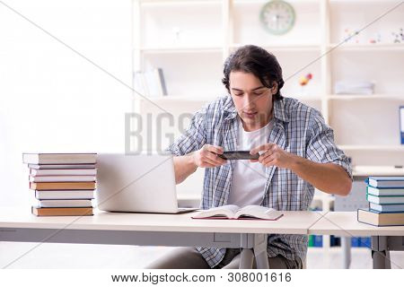 Young male student preparing for exams at home 