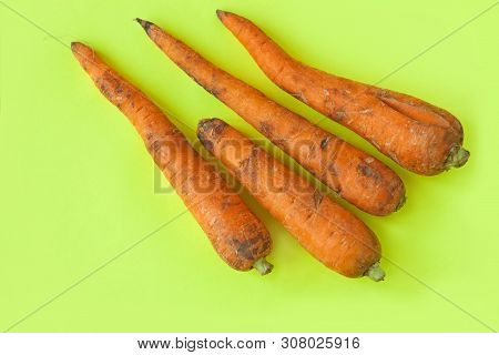 Ugly Food. Deformed Organic Carrots On The Pastel Yellow Background. Bright Colors. Misshapen Produc