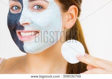 Woman With Clay Carbo Black Mask On One Half Face And White Mud On Second Half. Girl Removing Cosmet