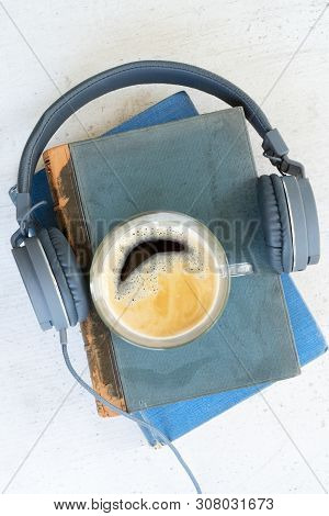 Audio Book Concept. Headphones With Books And Cup Of Fresh Coffee On Wooden Table. Top View