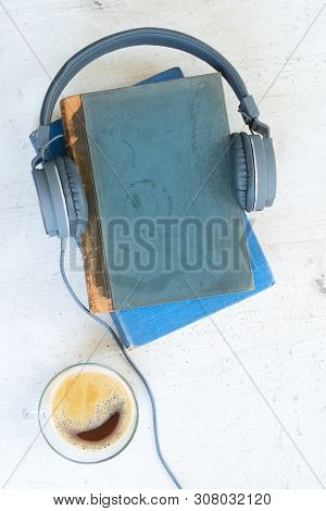 Audio Book Concept. Headphones With Books And Cup Of Coffee On Wooden Table. Top View