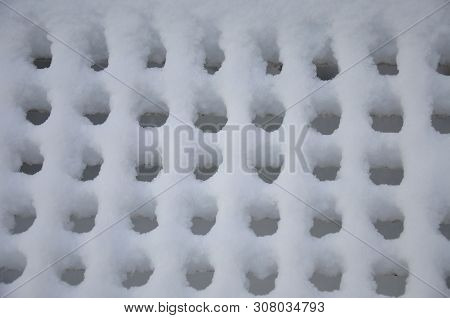 White Fluffy Snow Formed A Rhythmic Pattern On The Trellis.