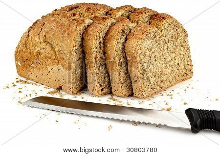 una hogaza de pan con un tres rebanadas y un cuchillo