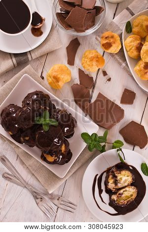 Chocolate Profiteroles With Whipped Cream On White Dish.