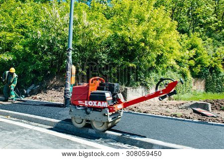 France - May 14, 2014: Black Ethnicity Man Working Posing Asphalt On French Trottoir Roadworks