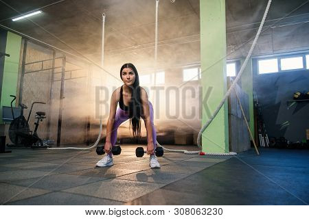 Young Fit Woman Doing Exercise With Dumbbells In The Gym.