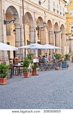 Fermo, Italy - June 23, 2019: People enjoying summer day and food at outdoor restaurant and resting, Piazza del Popolo, Fermo, Italy