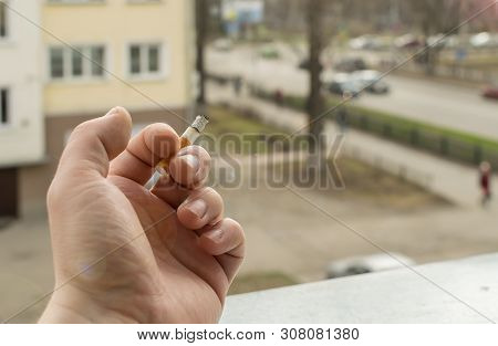 View Of The Hand Of A Smoking Man With A Smoking Cigarette From The Window Of The Apartment Into The