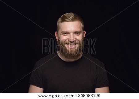 Close Up Portrait Of Young Man Isolated On Black Studio Background. Photoshot Of Real Emotions Of Ma