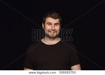 Close Up Portrait Of Young Man Isolated On Black Studio Background. Photoshot Of Real Emotions Of Ma