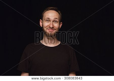 Close Up Portrait Of Young Man Isolated On Black Studio Background. Photoshot Of Real Emotions Of Ma