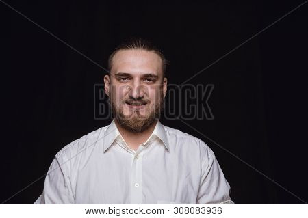 Close Up Portrait Of Young Man Isolated On Black Studio Background. Photoshot Of Real Emotions Of Ma