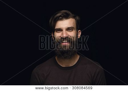 Close Up Portrait Of Young Man Isolated On Black Studio Background. Photoshot Of Real Emotions Of Ma