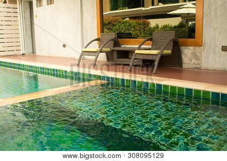Warm Light Neutral And Pool With Two Wicker Chairs