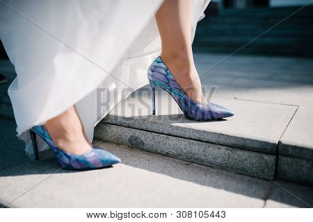 The Legs Of The Bride In A Wedding Dress In Shoes Close Op