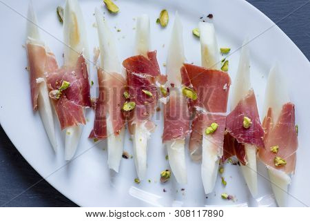 Still life of jamon serrano with yellow melon