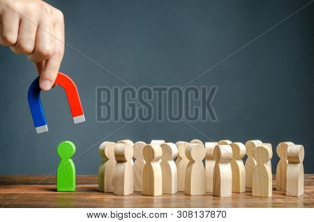 A Hand With A Magnet Is Trying To Pull A Green Figure Of A Person Out Of A Crowd. Recruiting New Wor