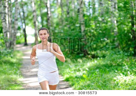 Young woman jogging through a park