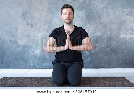 Young Sporty Man Practicing Yoga Lesson Sitting In Vajrasana Pose