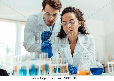 Nice Young Man Helping His Colleague With The Research