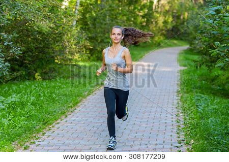 Running Woman Atletic Spotsman Trains In The Summer Park. Outdoor Fitness Portrait