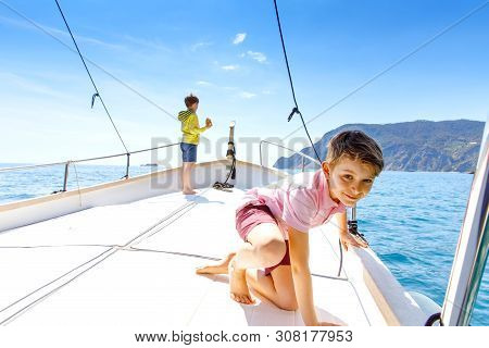 Two Little Kid Boys, Best Friends Enjoying Sailing Boat Trip. Family Vacations On Ocean Or Sea On Su
