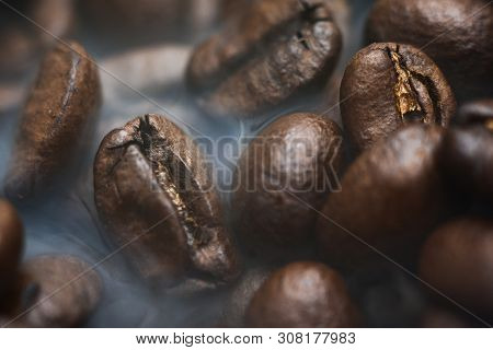 Roasted Coffee Beans With Smoke. Coffee Background.