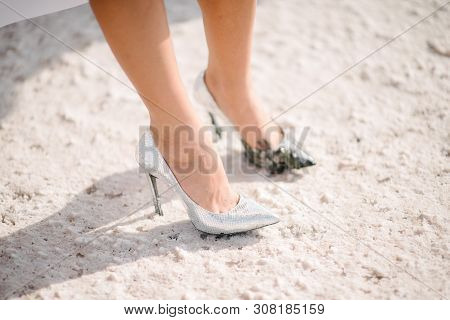 The Legs Of The Bride In A Wedding Dress In Shoes Close Op