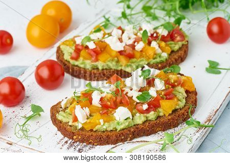 Avocado Toast With Feta And Tomatoes, Smorrebrod With Ricotta, Closeup