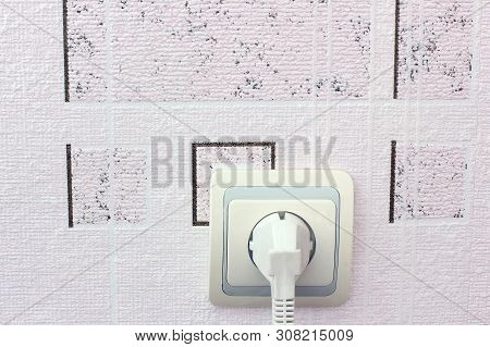 Socket In The Wall. Power Plug. An Electrical Appliance Is Plugged Into The Outlet