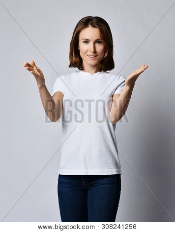 Nice Smiling Woman In White T-shirand Blue Jeans Shows Size Of Something Big With Her Arms With Open