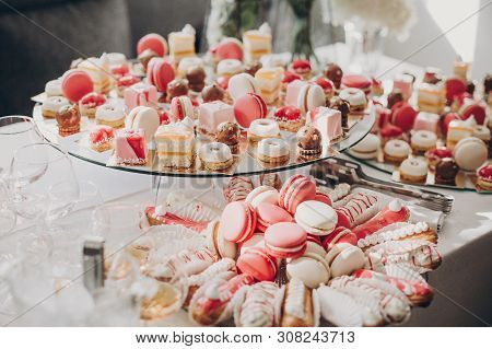 Delicious Pink Candy Bar At Wedding Reception. Pink And White Desserts,macarons And Cupcakes On Stan