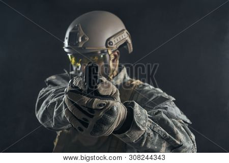 Front View Of Seriously American Soldier In Uniform Holding Modern Gun In Hands And Shooting At Came