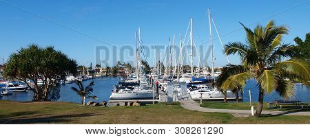 Landscape Panorama With Boats Berthed At A Tropical Waterfront Marina Including Palm Trees And Blue 