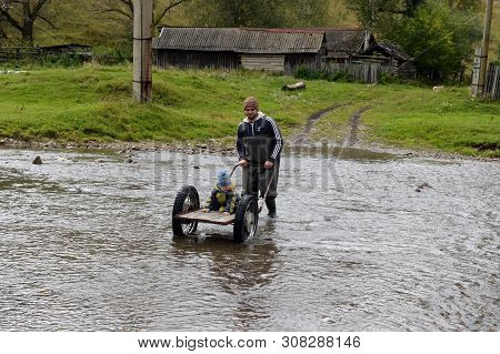 Altai Region, Russia - September 4, 2018: Local Residents Wade Through A Mountain River Yarivka In T