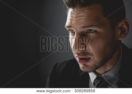 Man In Shadow With Serious Face Staring At Interlocutor In Interrogation Room