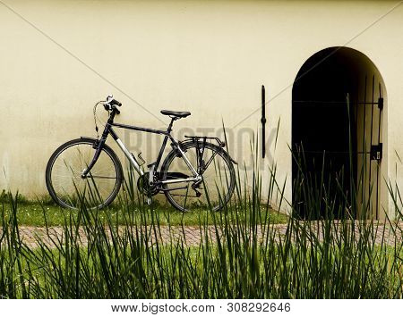 Alone Bicycle Waiting For Near Wall And Open Door Closeup Outdoors