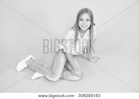 Girl Happy Face Sit On Floor Attentive Looking At Camera Turquoise Background. Kid Girl With Long Ha