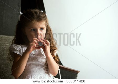 Interaction Of Children With Adult World. Cute Girl Trying To Do Bright Make Up For Being Older. Lit