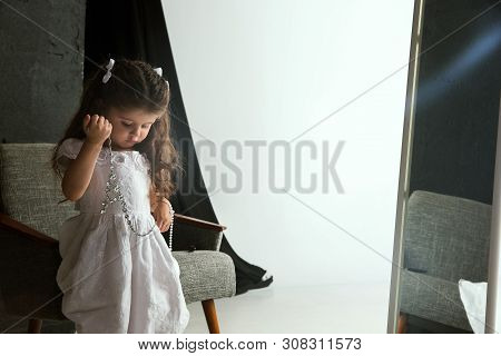 Interaction Of Children With Adult World. Cute Girl Trying To Do Bright Make Up For Being Older. Lit