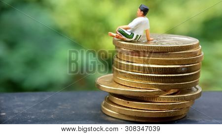Close Up Conceptual, Midle Aged Man Enjoy His Earn Or Income, Sit At Stack Of 500 Golden Coins, With